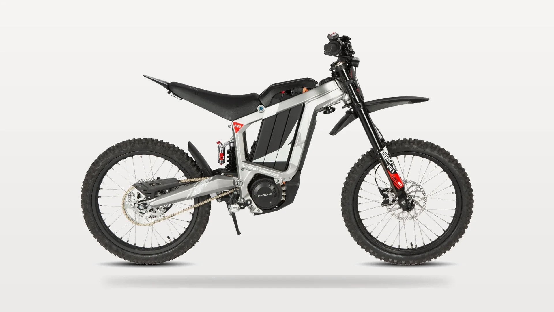 Eunorau R1 electric dirt bike in silver, full side profile showing footpegs, mid-motor and 19-inch wheels