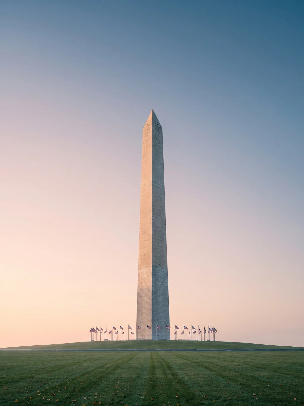 Washington DC eBike Laws 2026 cover: the Washington Monument on the National Mall at first light, its marble obelisk and pyramidion above the ring of flags at the base