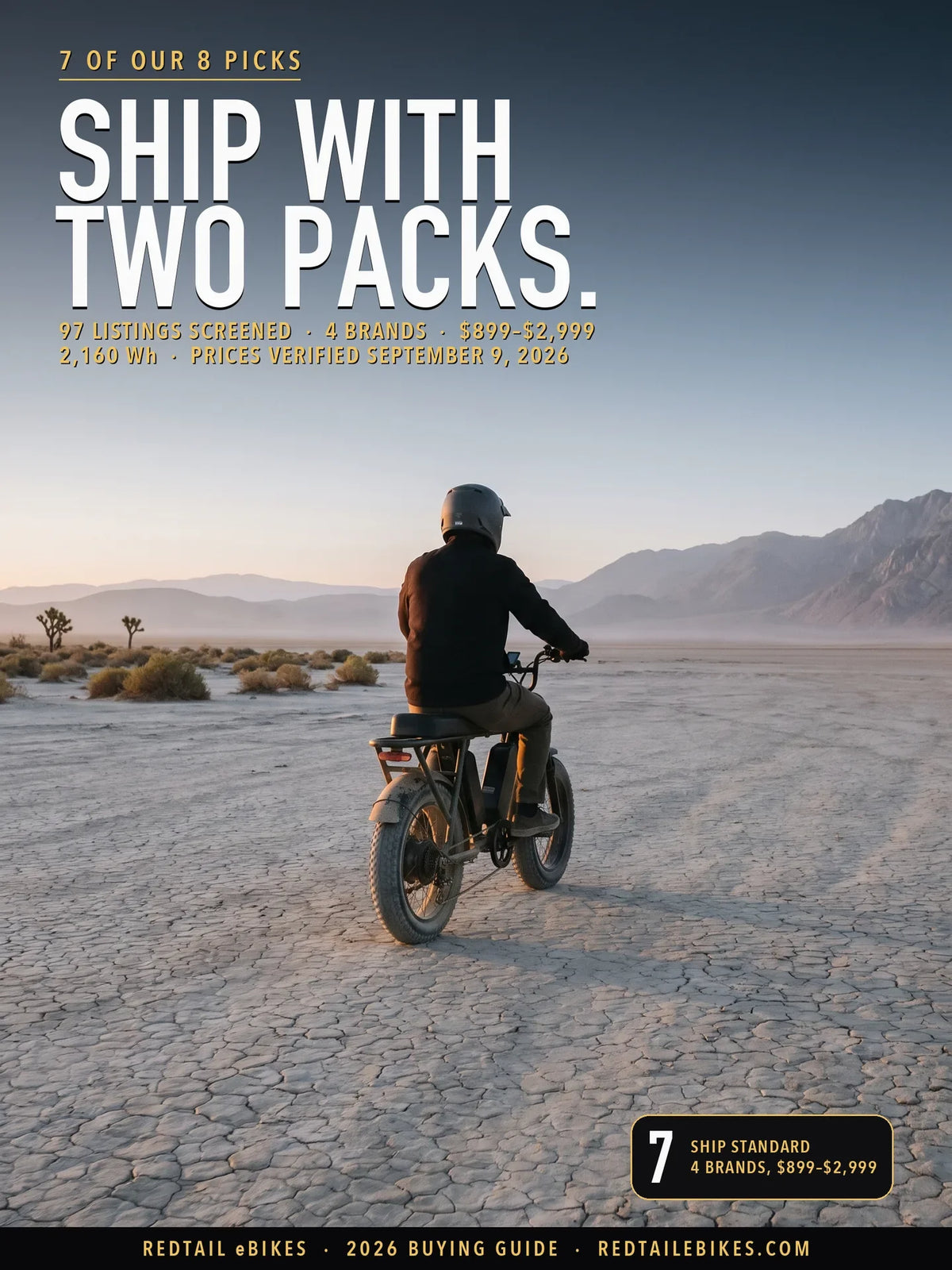 Rider on a dual battery electric bike crossing a dry lake bed at dawn, both battery packs visible in the frame