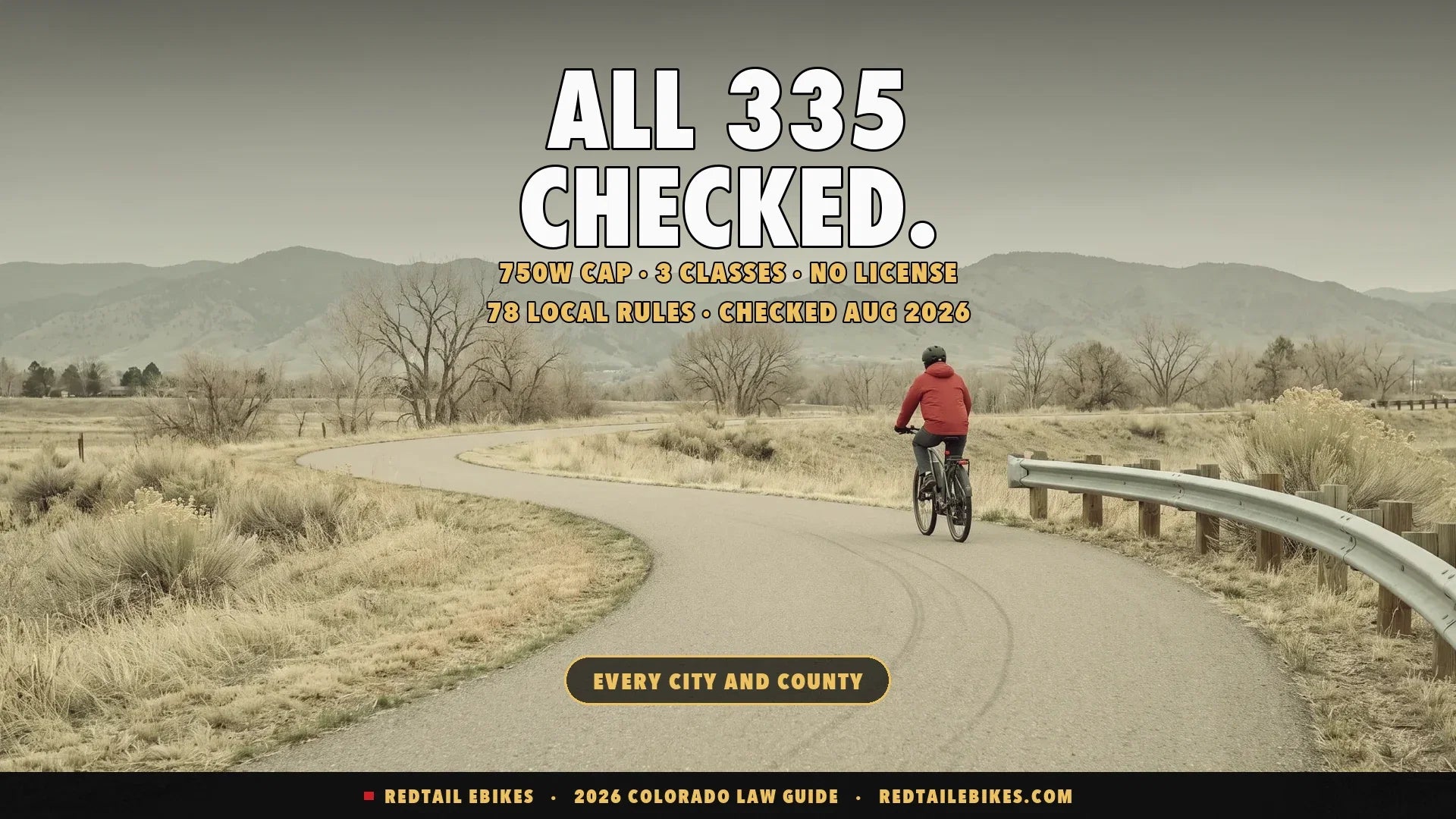Cyclist riding an electric bike on a paved mountain trail in Colorado with peaks in the distance