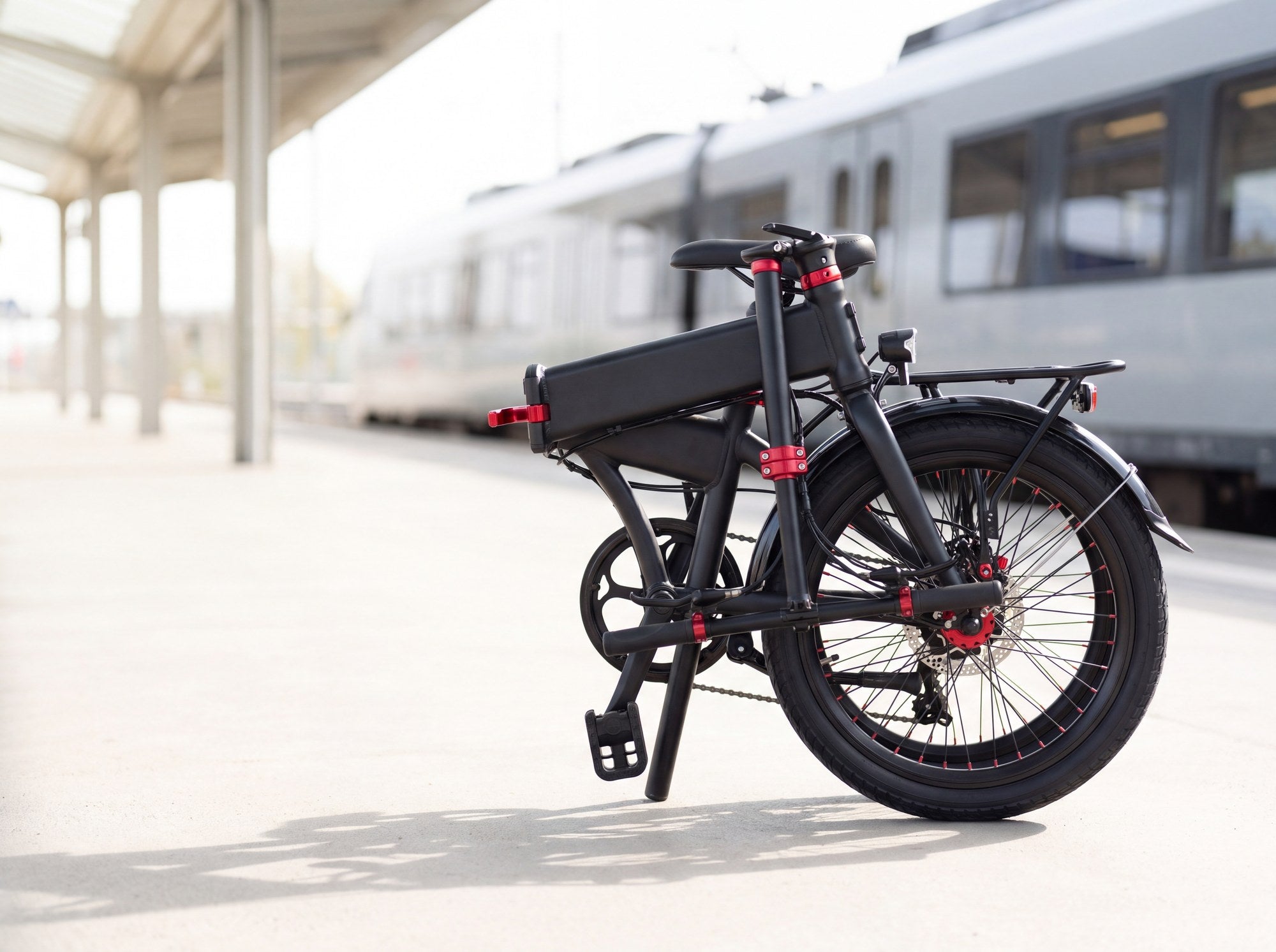 Redtail folding electric bike shown folded on a train platform