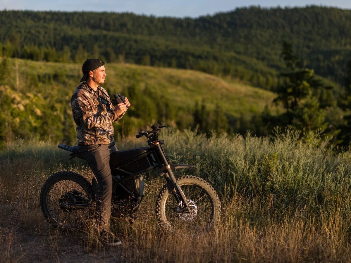 Rider standing with a Riding'times GT73 Pro electric motorbike in golden-hour hill country