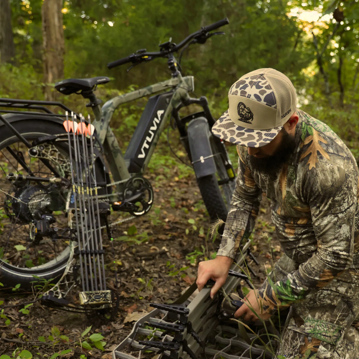 Hunter loading a bow onto the rear rack of a camo SN100