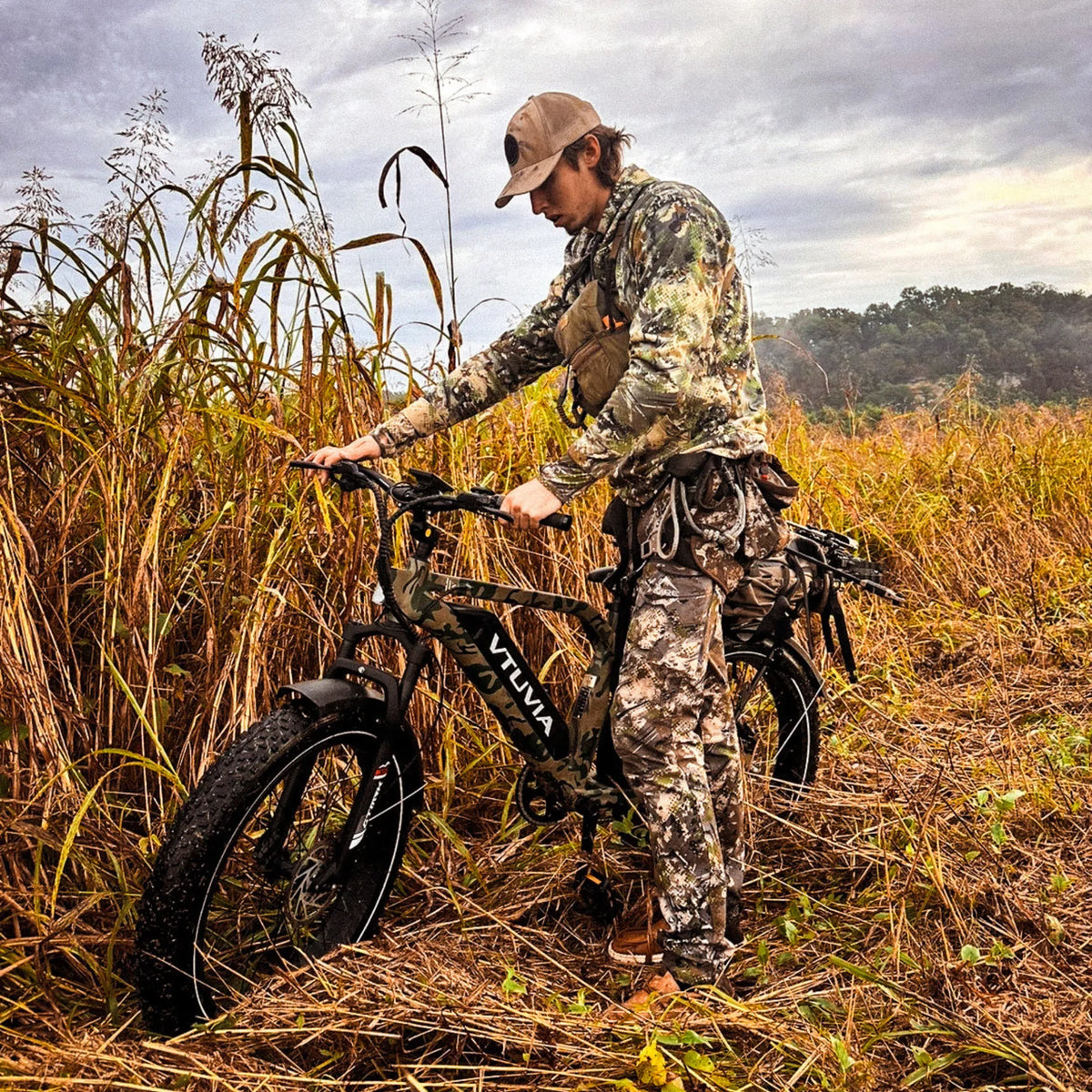 Hunter walking a camo SN100 through tall autumn grass