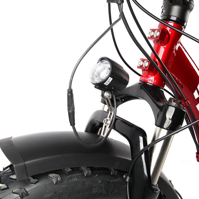 The headlight fitted above the fender of a red VTUVIA