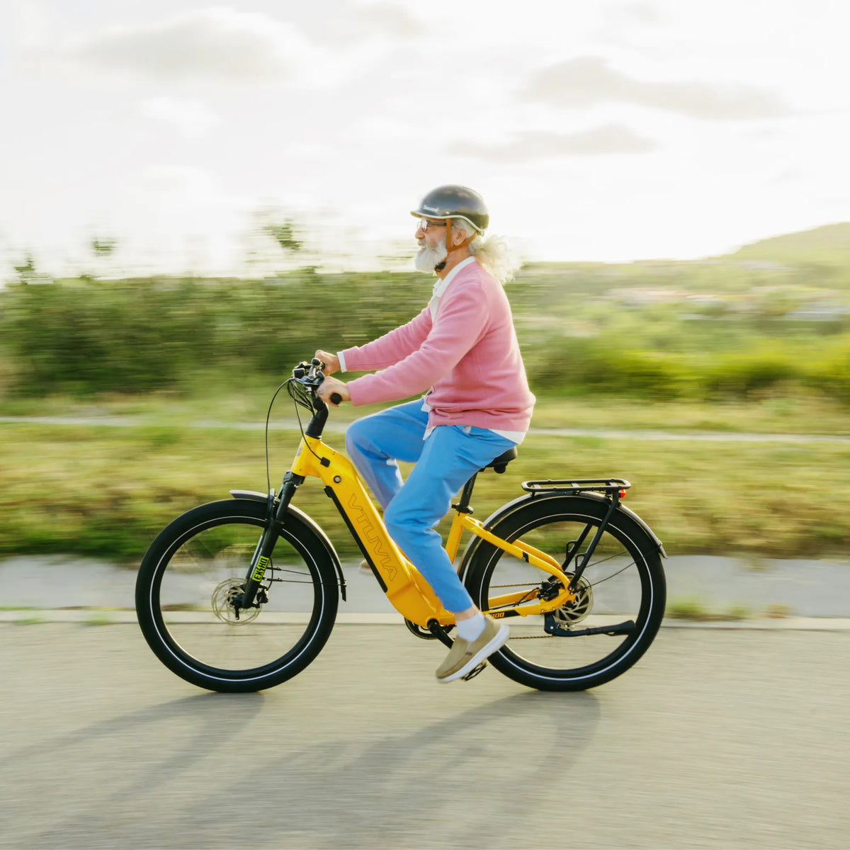 Rider on an orange Zeal LT7 at speed on a coastal road