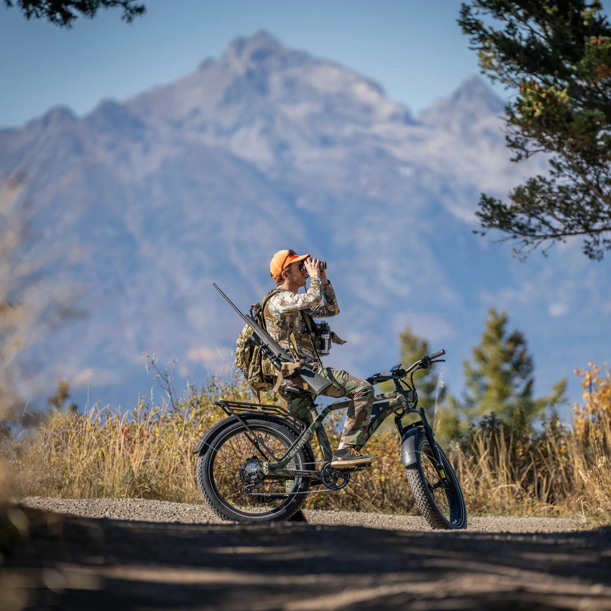Hunter glassing from beside an SN100 on a mountain road