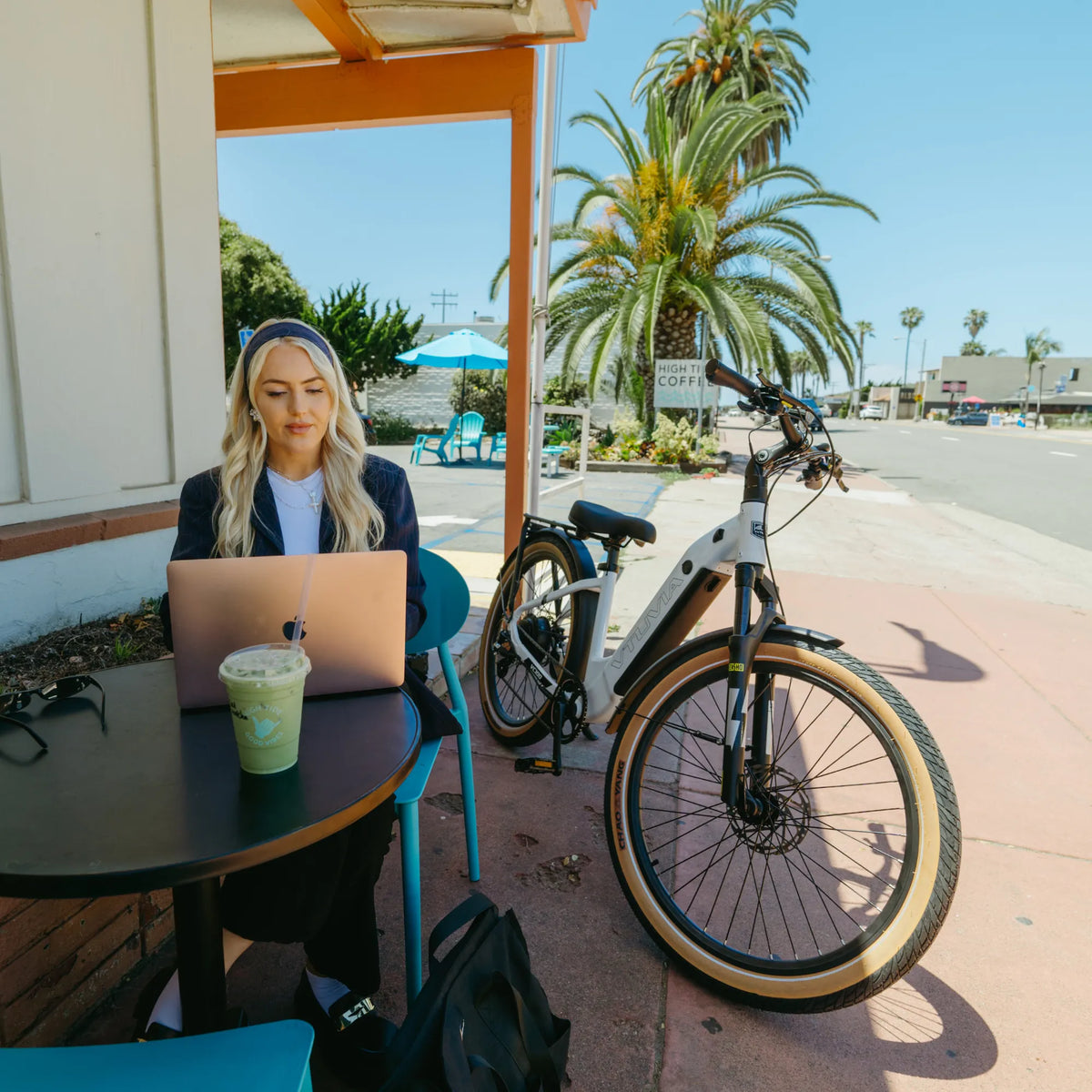 White Zeal XT8 parked beside a cafe table where its rider works on a laptop
