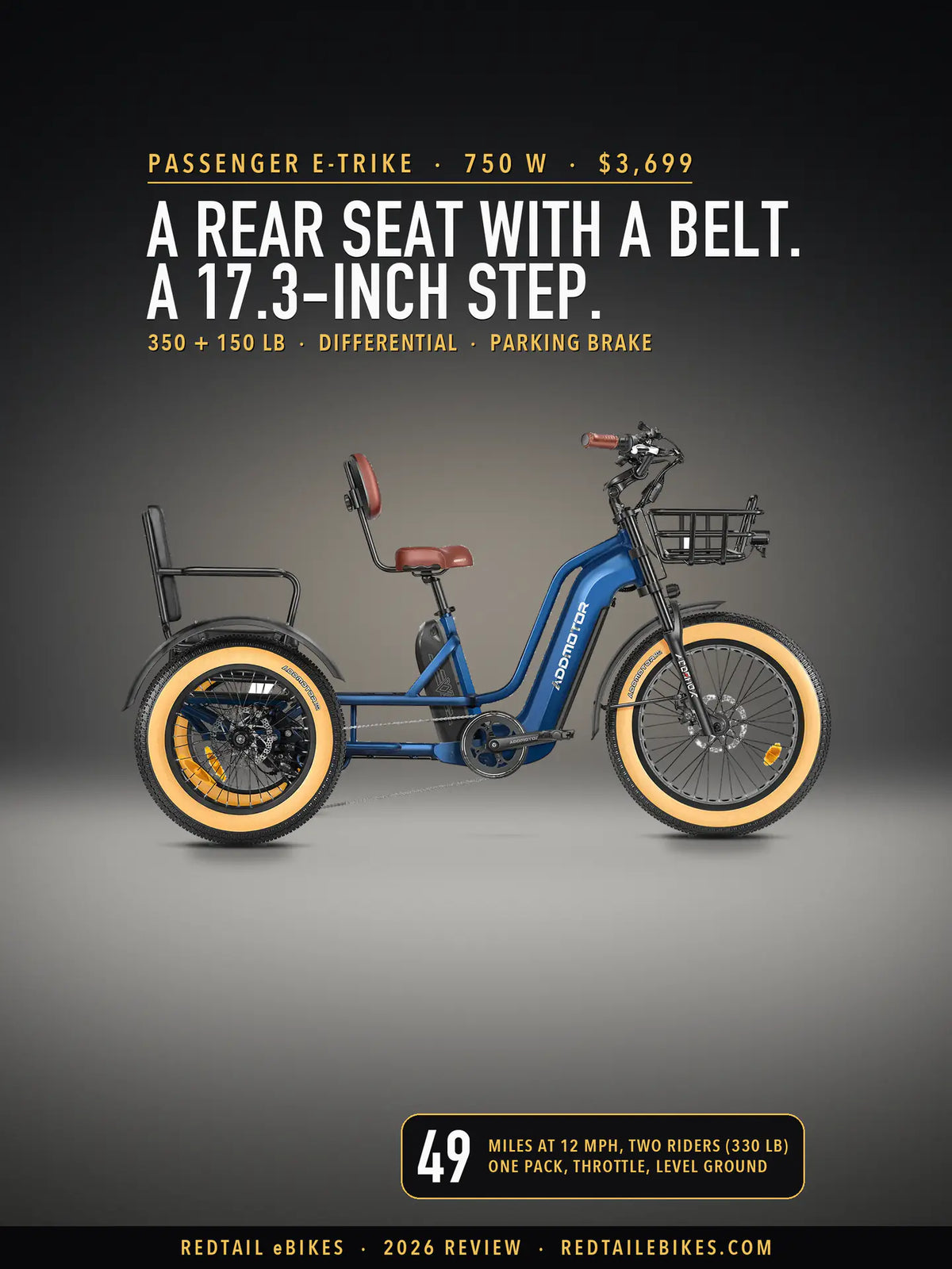 Addmotor Greattan L passenger e-trike in Neptune Blue on a lit studio floor against a dark wall, side view, with its brown saddle and backrest, the black passenger seat with armrests over the rear wheels and a front basket