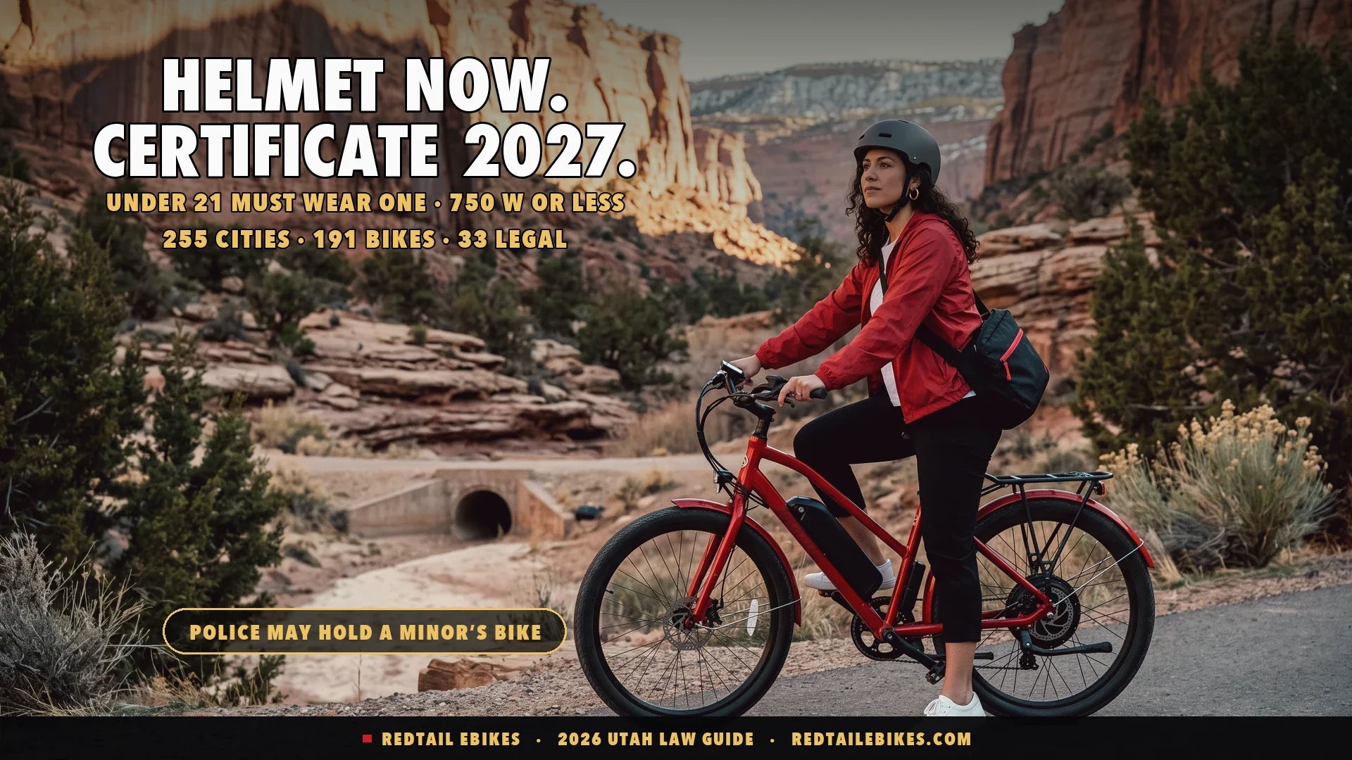Rider in a fitted helmet on a red electric commuter bike on a paved canyon trail below red sandstone cliffs at first light, juniper and slickrock along the path