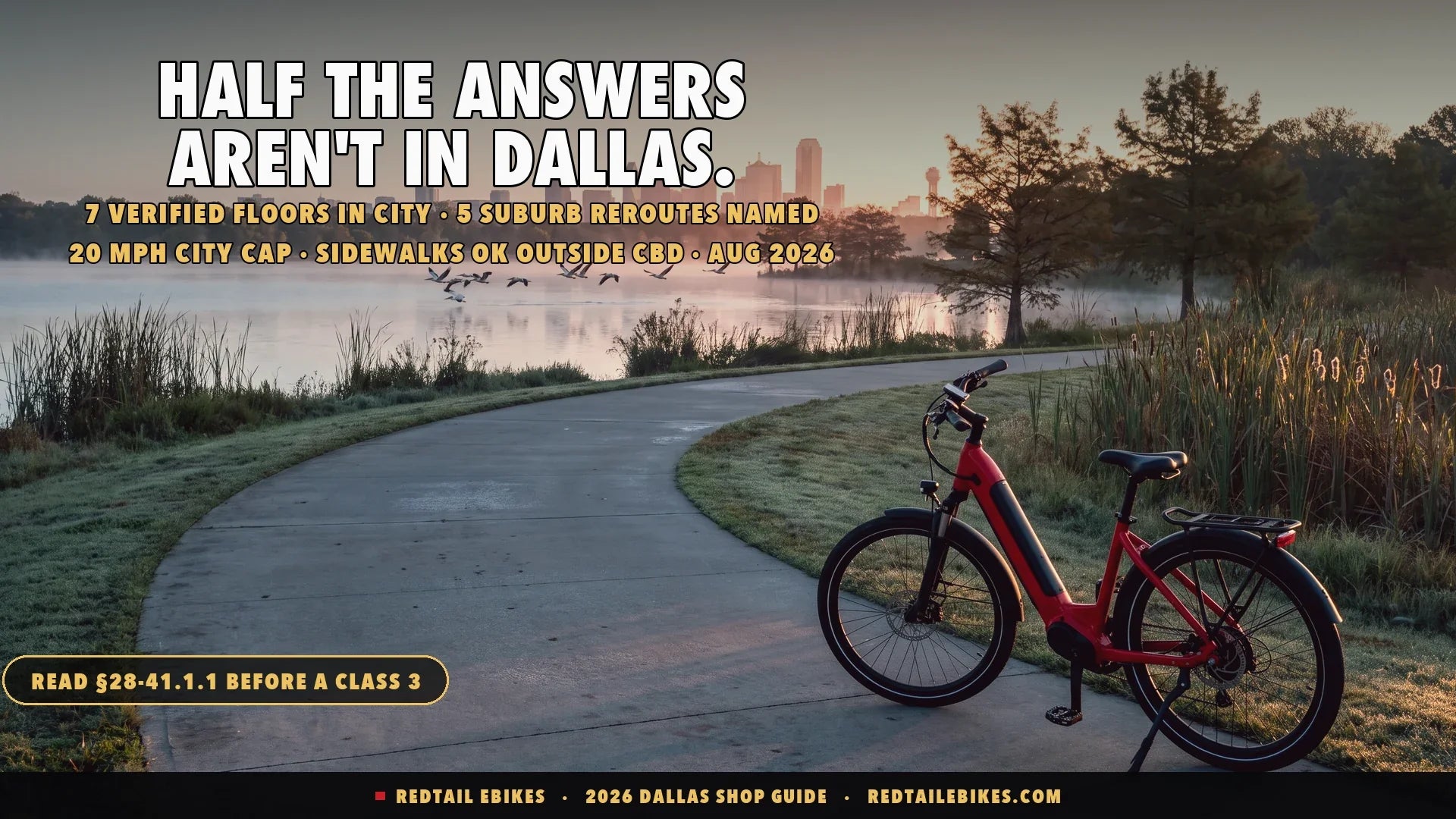 Red step-through electric bike on the White Rock Lake trail at sunrise with the Dallas skyline across the water