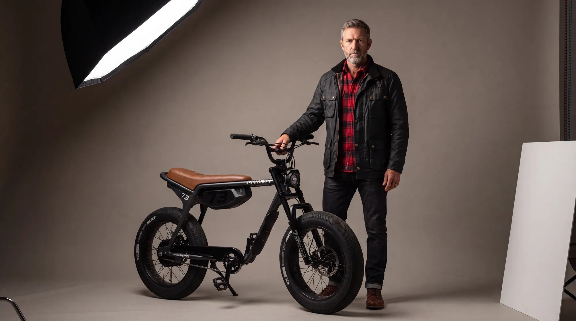 Super73 moto-style e-bike with fat tires and a banana seat parked on a city street