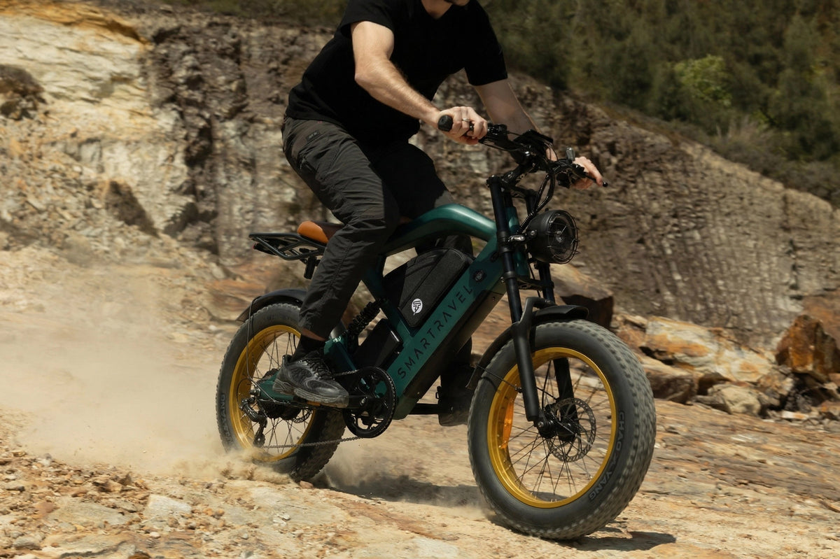 Smartravel Raptor ST202 GPS Fat Tire Electric Bike in green, ridden across a dusty dirt slope below a rock face