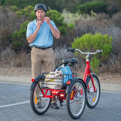 A rider buckles a helmet beside a red MG708 Hera with shopping bags in its rear basket