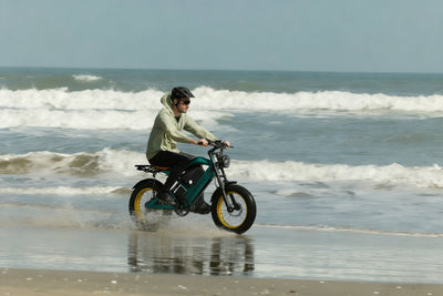 Smartravel Raptor ST202 GPS Fat Tire Electric Bike in green, ridden through shallow surf along a beach