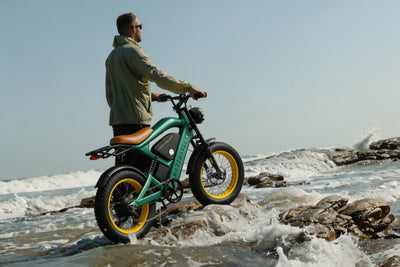 Smartravel Raptor ST202 GPS Fat Tire Electric Bike in green on wet shoreline rocks as a wave breaks behind it