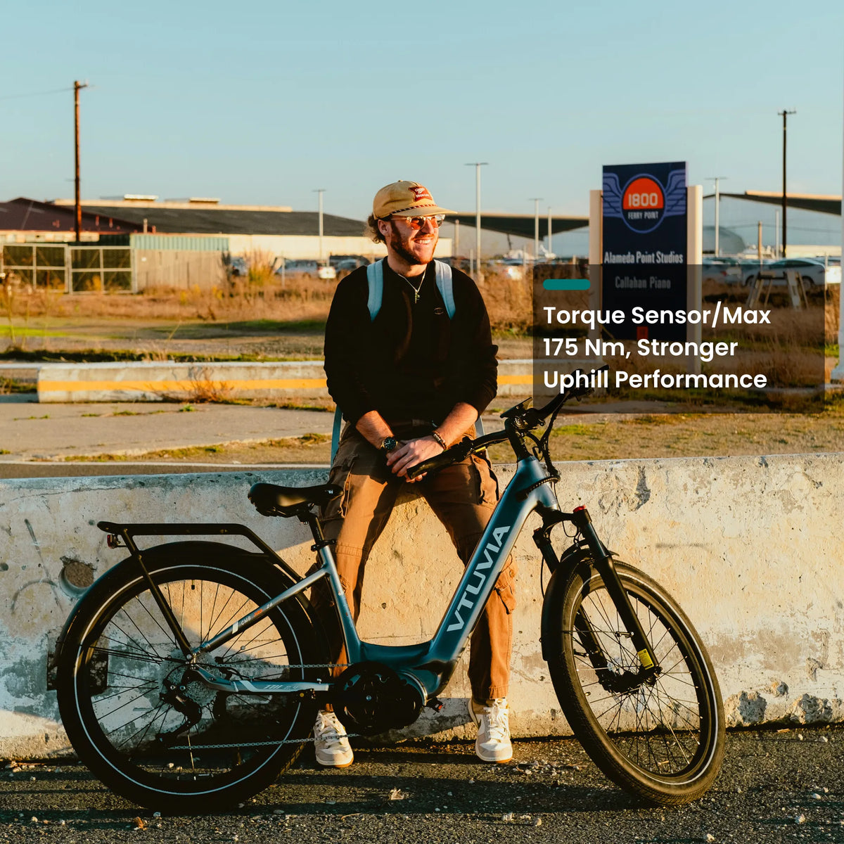 Rider leaning on a dark green CMB beside an industrial lot