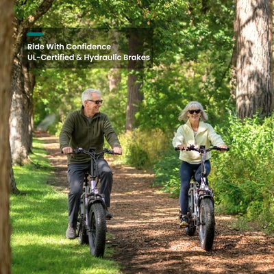 Two riders on SF20H folding bikes on a shaded dirt trail