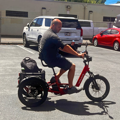 Rider on a red E-Cozy trike with a bag in the rear basket