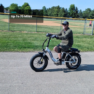 Rider on an SF20H on a paved path beside a baseball field