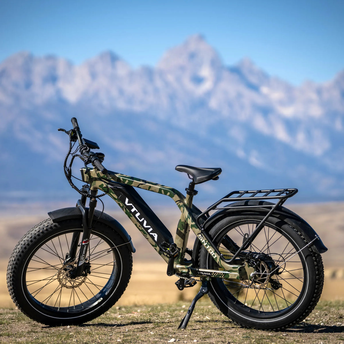 Camo SN100 parked on a gravel road below the Tetons