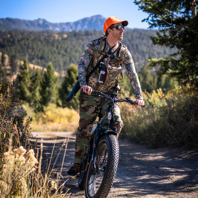 Hunter riding a camo SN100 along a mountain trail
