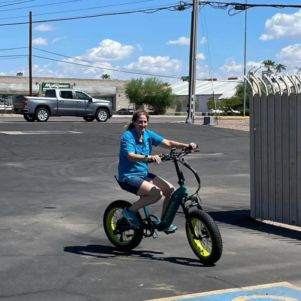 Rider pulling away on a teal SX20 across a parking lot