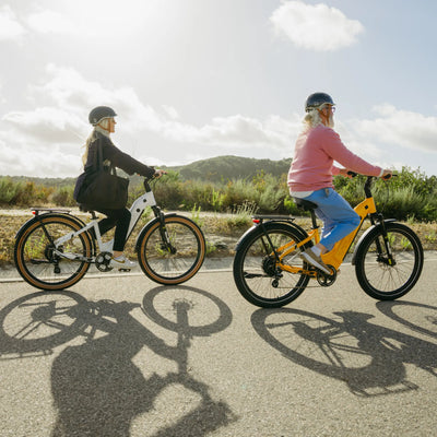 Two riders on Zeal bikes on a coastal path, long shadows