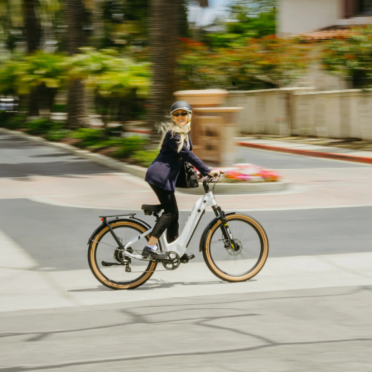 Rider on a white Zeal XT8 accelerating along a palm-lined street
